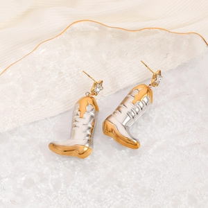 Detailed close-up of cowboy boot earrings with silver finish and gold-tone accents on a tray