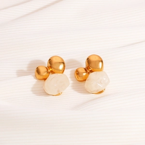 Irregular resin and 18K gold-plated stainless steel earrings on white textured fabric