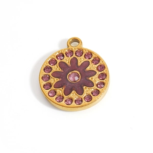 Close-up of a 18K gold-plated round pendant with purple flower design and crystals