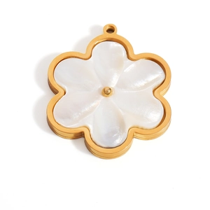 Macro detail of 18K gold petal flower pendant with white shell inlay and center bead