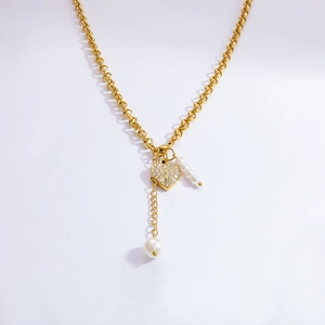 Détail d'un collier en Y doré avec pendentif coeur brillant et perles élégantes