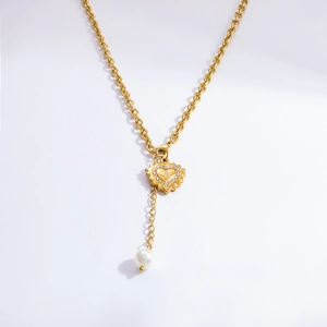 Détail du pendentif cœur en or 18K avec œil protecteur et perle blanche pendante