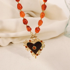 Vintage roestvrijstalen ketting met barnsteenkleurige harskralen en goudkleurig kanten hart