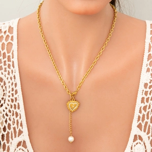 Collier élégant doré avec pendentif cœur, perles et strass sur fond de dentelle