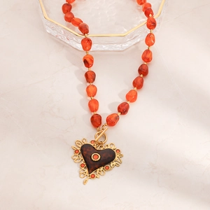 Detail van vintage hart hanger ketting met amber hars kralen en 18K gouden OT sluiting