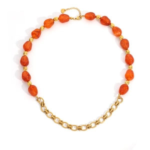 Detail van kralenketting met amberkleurige harsstenen en gouden roestvrijstalen schakels