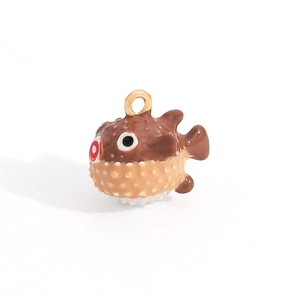 Macro shot of cartoon pufferfish pendant with brown textured spikes and golden ring