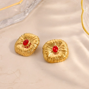 Orecchini vintage placcati oro con rubino rosso su sfondo di marmo elegante