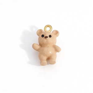 Detail of a milk tea bear charm with a smooth glazed finish and golden loop for DIY jewelry