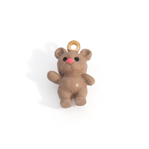 Detailed macro view of a brown resin bear pendant with a gold ring and pink nose detail