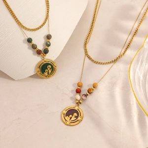 Détail d'un collier double couche doré avec perles colorées et pendentifs fleurs vintage