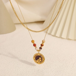 Détail d'un collier en acier inoxydable doré à deux rangs avec perles et pendentif fleur
