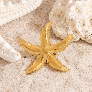 18K gold plated starfish brooch with realistic texture on a sandy beach background