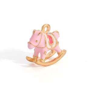 Detailed macro view of pink and red enamel rocking horse pendant in gold plating