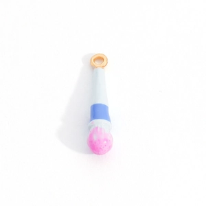 Detailed close-up of a colorful enamel makeup brush charm with pink bristles and gold ring