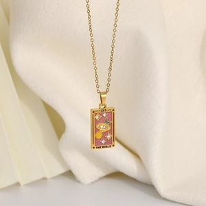 Makroaufnahme von 18K Gold Tarot Anhänger mit rosa Emaille THE WORLD Design und Kristallen