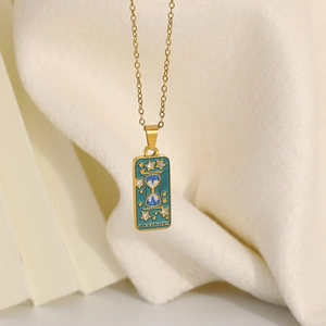 Makroaufnahme der 18K Gold-Tarot-Halskette mit blauem Emaille und Carpe Diem Text
