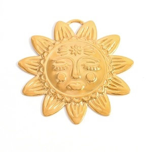 Détail d'un pendentif visage de soleil doré avec gaufrage floral et rayons radiaux