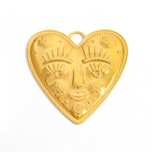 Détail du pendentif coeur doré avec visage sculpté, fleurs et bordure perlée