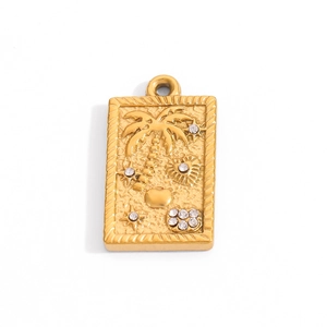 Détail du pendentif plaqué or 18 carats avec gravures de palmier et cœur en relief