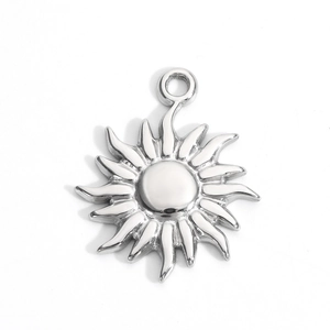 Detailed view of a silver sun-shaped pendant with wavy rays and a polished mirror finish
