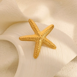 Détail de la broche étoile de mer plaquée or 18 carats avec texture sur céramique