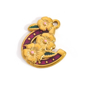 Detail of horseshoe floral pendant in gold finish with purple and green enamel inlay