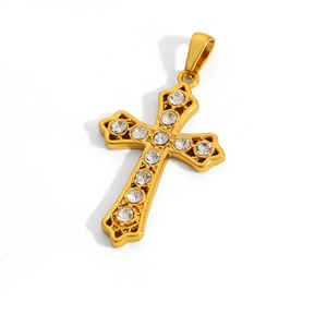 Macro detail of golden cross pendant with sparkling clear zircons on a white background