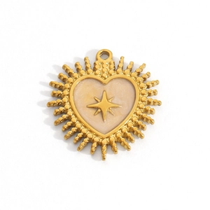 Detail of a golden heart pendant with pearl enamel and engraved octagonal star