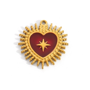 Detailed view of a gold heart charm with red enamel and a central star motif