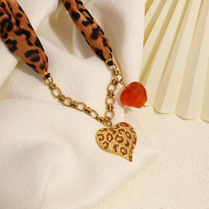 Collana a foulard in seta leopardata con ciondolo a cuore e catena dorata su bianco