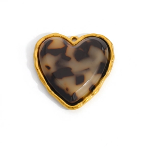 Detailed view of heart-shaped gold-rimmed pendant with a tortoiseshell resin inlay