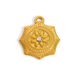 Detail of vintage gold star-shaped pendant with central crystal and floral metal relief