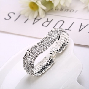 Detail of multi-row rhinestone pave link bracelet with silver finish on ceramic plate
