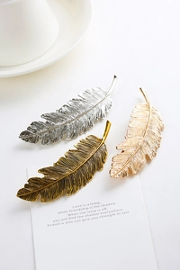 Three-piece metal feather hair clip set in silver, vintage gold, and bright gold finishes