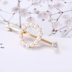 Elegant gold butterfly hair clip with white pearls and large crystal on white background