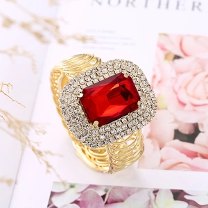 Dettaglio di un anello con grande pietra rossa rettangolare e triplo bordo di strass