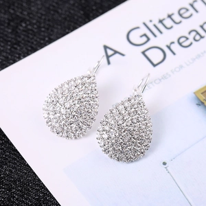 Élégantes boucles d'oreilles goutte argentées avec cristaux sur fond de carte blanche