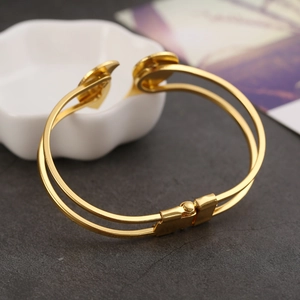Detail of golden double-band heart bracelet with a secure mechanical push-lock buckle