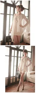 Detail of elegant beige one-shoulder chiffon dress with asymmetric cape sleeve design