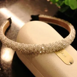 Elegant wide headband featuring rows of clear crystal beads on a minimalist cream base