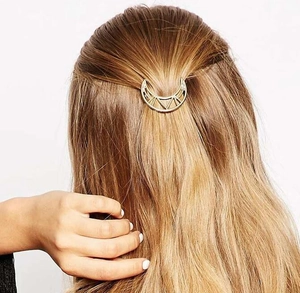 Barrette à cheveux lune dorée portée sur une coiffure minimaliste élégante