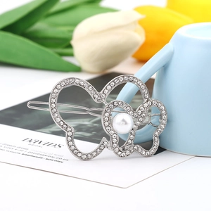 Detailed view of silver butterfly hair clip with rhinestones and a central pearl