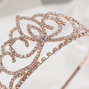 Macro close-up of rose gold bridal crown with shimmering rhinestones and intricate patterns