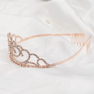 Macro view of rose gold bridal crown with crystal heart patterns and hair combs