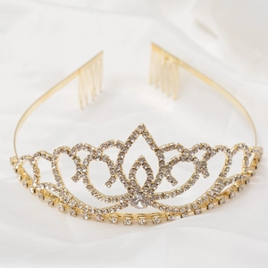 Macro view of a gold bridal crown with white rhinestones on white silk fabric background