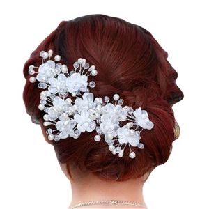 Elegant bridal hair pin with white flowers and pearls on dark auburn hair bun
