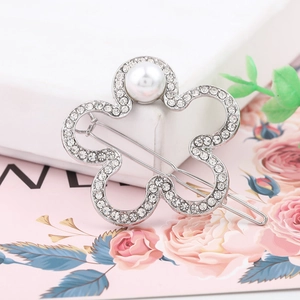 Elegant floral hair clip with white crystals and pearls on a silver metal bobby pin