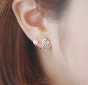 Vue macro d'ensemble de boucles d'oreilles rose doré avec tournesol et perles