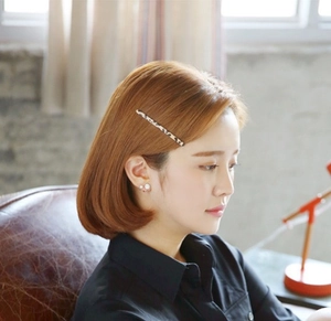 Gros plan d'une barrette léopard et de boucles d'oreilles en perles portées par un mannequin